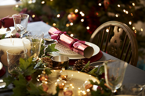 Christmas table setting decór with Christmas tree and fairy lights and Christmas cracker classy elegant